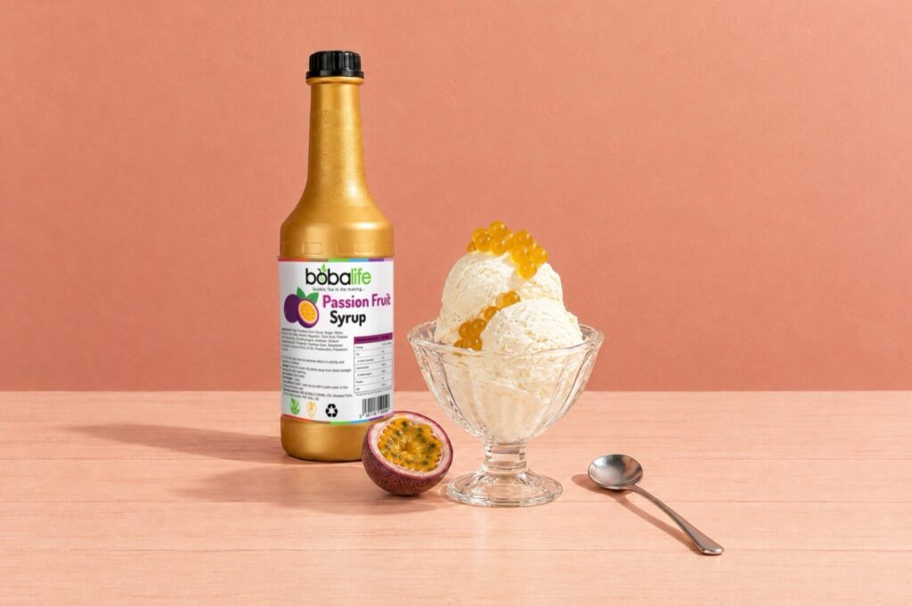 Passion fruit syrup bottle beside an ice cream topped with passion fruit popping boba